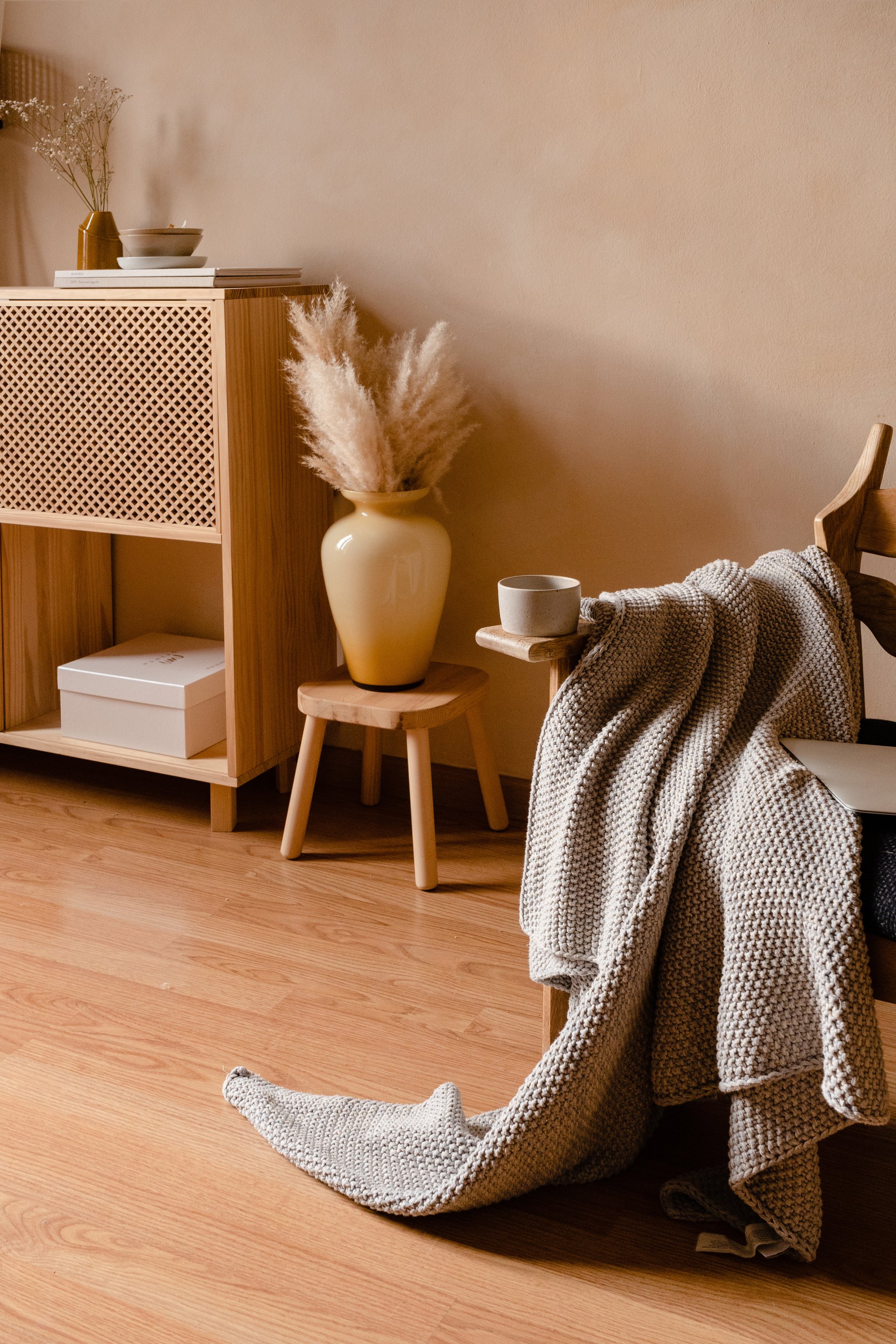 Empty Mug and Plaid on Wooden Armchair